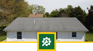 A single-story white house with gray shingles and white shutters, surrounded by green trees, highlights quality roofing in Florida. A green square with a white gear and wrench icon overlays the bottom center of the image.
